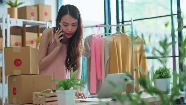 small business fashion store shop onwer discuss checking business order contract deal at home while conversation on smartphone and checking cloth inventory and order checking for make sure 