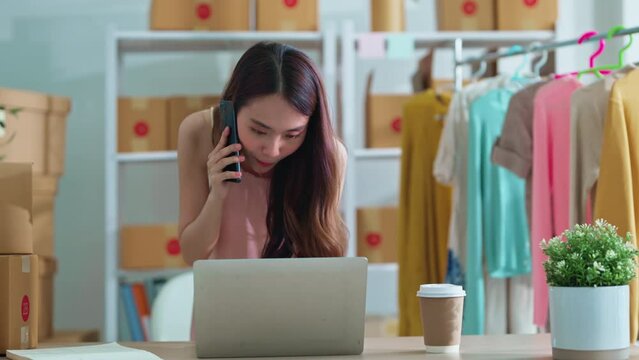 small business fashion store shop onwer discuss checking business order contract deal at home while conversation on smartphone and checking cloth inventory and order checking for make sure 