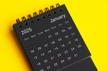 January 2025 black and white desk calendar on yellow cover background. Calendar concept