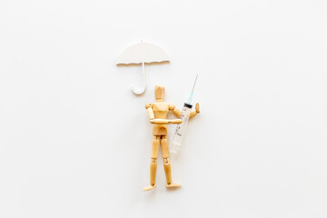 Medical insurance concept - wooden dummy man with umbrella