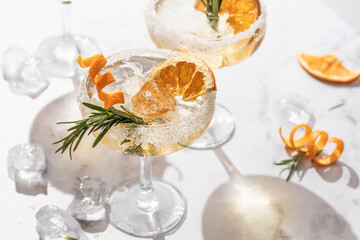 Two sidecar cocktails with sugar rims on white marble table. Festive party composition