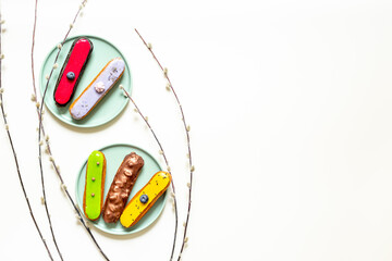 Set of various glased eclairs with chocolate and berrie, top view