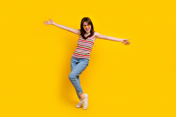 Full body photo of funny pleasant cheerful girl wear striped tank denim trousers presenting herself...
