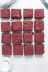 Top view of sliced fudgy red velvet brownies on a white marble tray, Overhead view of red velvet fudge brownies on a white background, homemade red brownies for valentines day