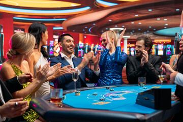 Group of Rich Glamorous People  Playing Card at Blackjack Table on a Casino Floor. Celebrating as a Lucky Man Hits the Jackpot after Croupier Dealing a Winning Hand. Cinematic Shot
