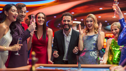 Group of Diverse Young People Gambling at a Casino. Beautiful Female and Handsome Male Guests Placing Risky Bets while Playing Roulette. Crowd Celebrating a Positive Outcome and Cheering the Winner