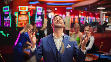 Portrait of an Excited Young Man Catching Money that is Flying From the Sky. Successful Gambler Won a Jackpot in a Casino. Concept of Gambling, Betting, Finance, Luxury and Success