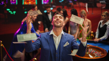 Happy Man in a Suit Standing in the Middle of a Modern Casino, Extending Arms, Welcoming a Money...