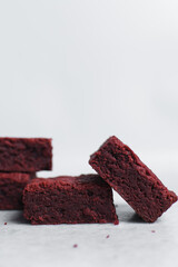 Thick red velvet brownies on a white tray, red velvet fudge brownies on a white background,...
