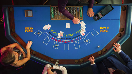 Top Down View Of Three Gamblers Playing Blackjack In Luxurious Casino. Professional Dealer...