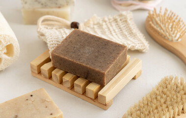 Brown handmade soap bar on soap saver bag near hygiene Items close up on white table