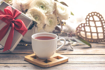 Background for Valentine's Day with a cup of tea and flowers.