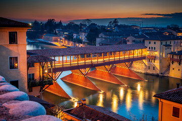 Bassano del Grappa, Italy - January 09, 2024: panorama of the Ponte degli Alpini in the evening - 706455023