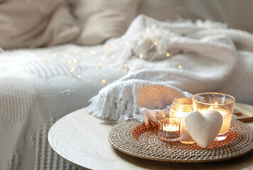 Home composition for Valentine's Day with candles in the interior of the room.