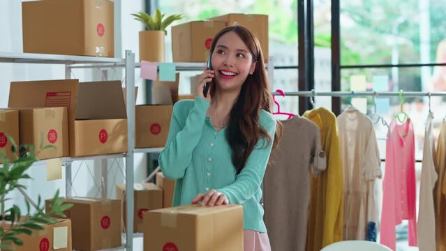 small business fashion store shop onwer discuss checking business order contract deal at home while conversation on smartphone and checking cloth inventory and order checking for make sure 