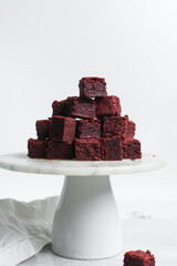 red velvet brownies on a white marble cake stand, red velvet fudge brownies on a white background
