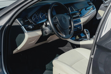 Interior of a business-class car, white perforated leather, aluminum, black lacquer, interior details.