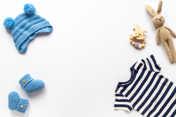 Set of baby boy dress - blue bodysuit with knitted hat and boots, top view. Kids clothing flat lay
