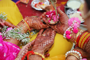 Closeup of flower in hands during haldi poojan in wedding