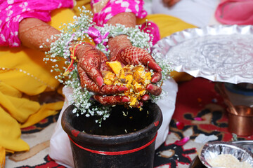 Closeup of hands doing pooja for haladi ritual before marriage