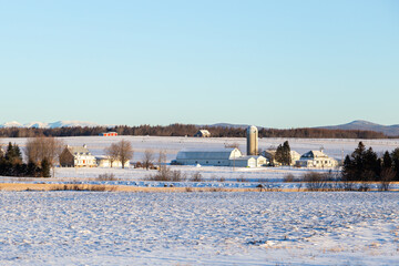 Early morning winter view of patrimonial houses and barns in farmland 