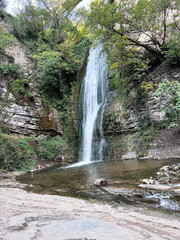 Fototapeta na wymiar waterfall white bridge over mountain rivers Tbilisi Botanical Garden