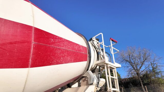 Close-up of a concrete mixer truck with rotating drum at a construction site
