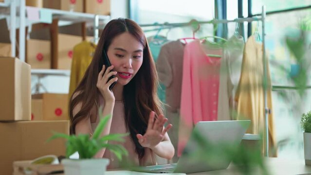 small business fashion store shop onwer discuss checking business order contract deal at home while conversation on smartphone and checking cloth inventory and order checking for make sure 