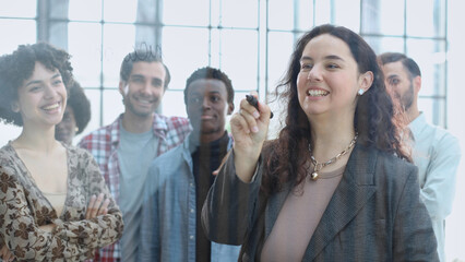 a team of young designers sticking notes on glass in a modern office