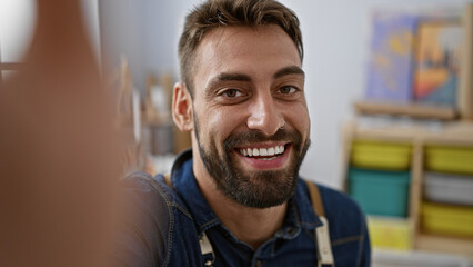 Vibrant young hispanic man, bearded art teacher smiling and confident, engaging in an inspiring...