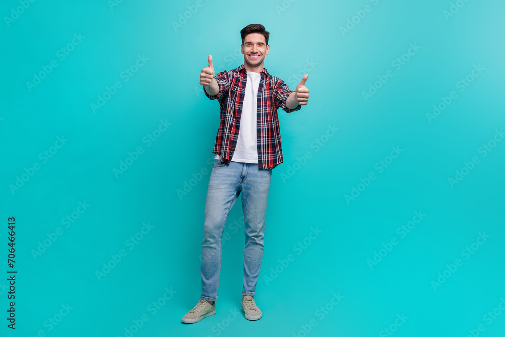 Poster full length photo of good mood funky man dressed plaid shirt showing you two thumbs up isolated turq