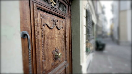 Obraz premium Ancient European door with wooden ornament, antique front entrance of residence with street