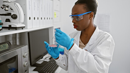 Serious african american woman scientist, fervently immersed in her work, poring over a crucial...