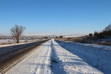 Fototapeta na wymiar A road with snow on the side