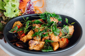 Stir-Fried Crispy Pork with Thai Basil is a popular Thai dish that is made with crispy pork belly, 