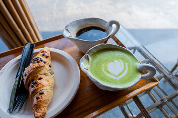 Close-up photo of green tea latte art paired with croissants