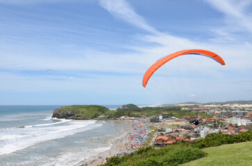 Panoramic view of the coast of Torres city with crowded beach - Paraglider - Praia da Cal - Torres, Brasil