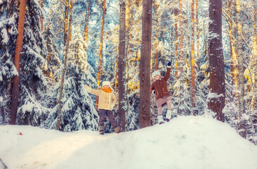 Children walk in a winter snowy forest.