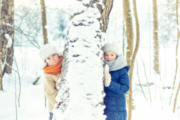 Children walk in a winter snowy forest.