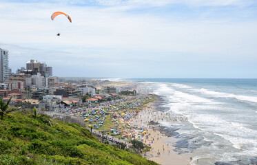 Panoramic view of the coast of Torres city with crowded beach - Paraglider - Praia Grande - Torres, Brasil