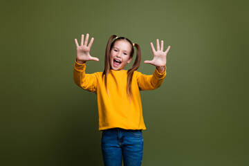 Portrait of clever smart kid with tails hairstyle dressed yellow sweatshirt showing palms count to...