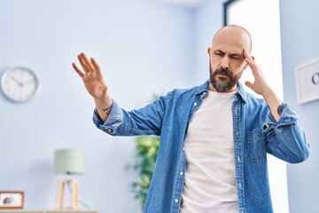 Young bald man suffering dizzy standing at home