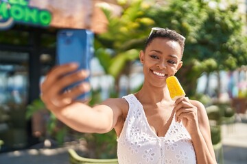 African american woman make selfie by smartphone eating ice cream at park