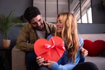 Loving young couple with heart-shaped gift box. Valentine's Day Celebration