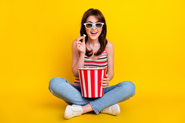 Full size photo of impressed woman dressed knitwear top in 3d glasses sit eat popcorn at home cinema isolated on yellow color background - obrazy, fototapety, plakaty