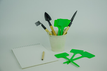 garden objects on a light background, watering can pots for planting, shovels with rakes for...
