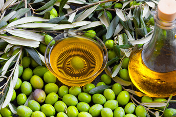Image of raw green olives and liquid olive oil
