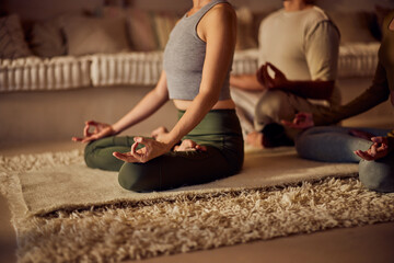 Close-up of a group of three people, doing a meditation, at home.