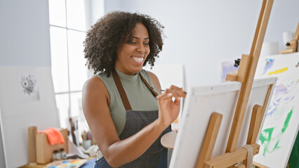 African american woman painting on canvas in a studio
