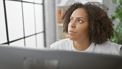 African american woman with braids working thoughtfully in modern office